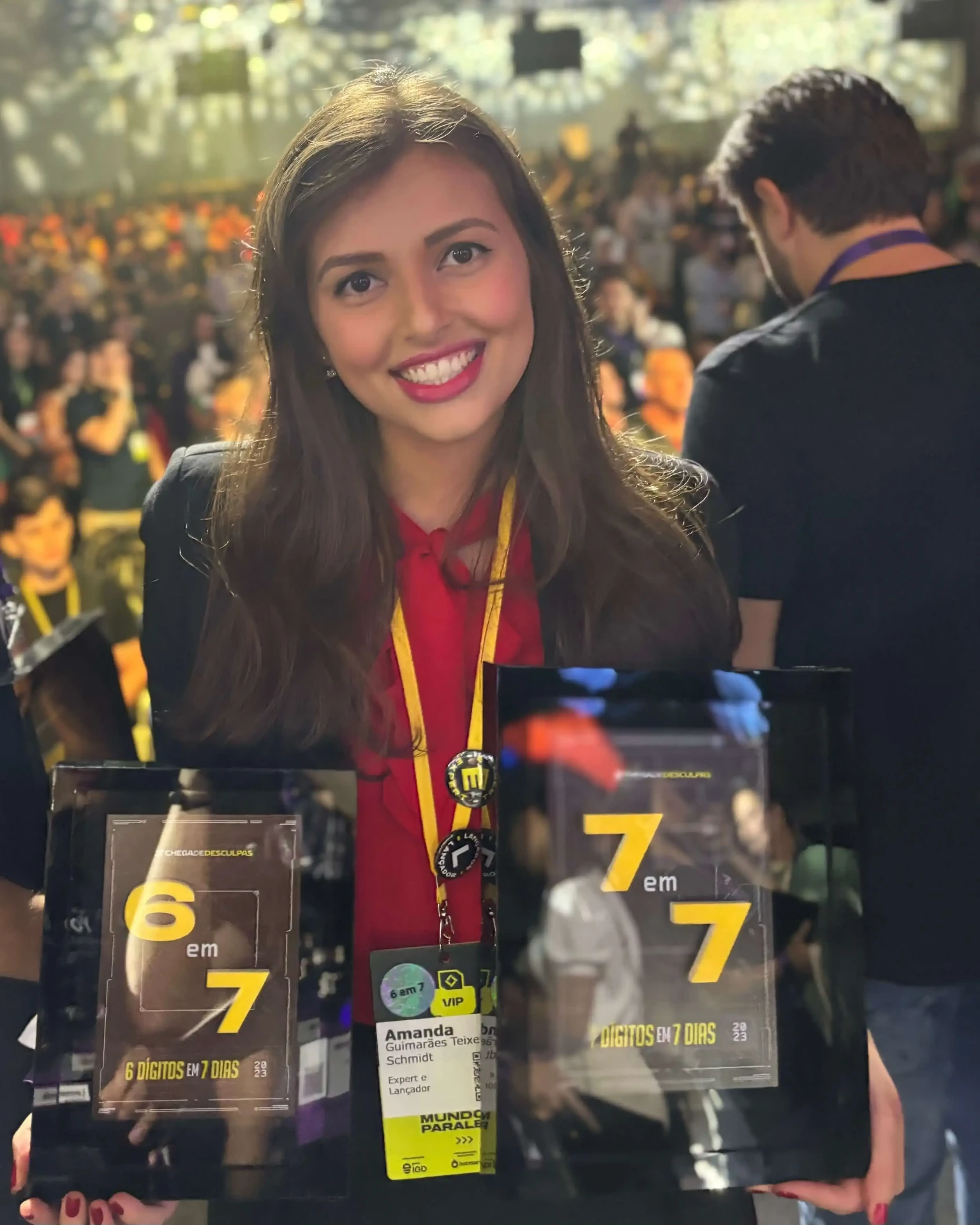 Amanda Schmidt sosteniendo placas de reconocimiento en evento digital